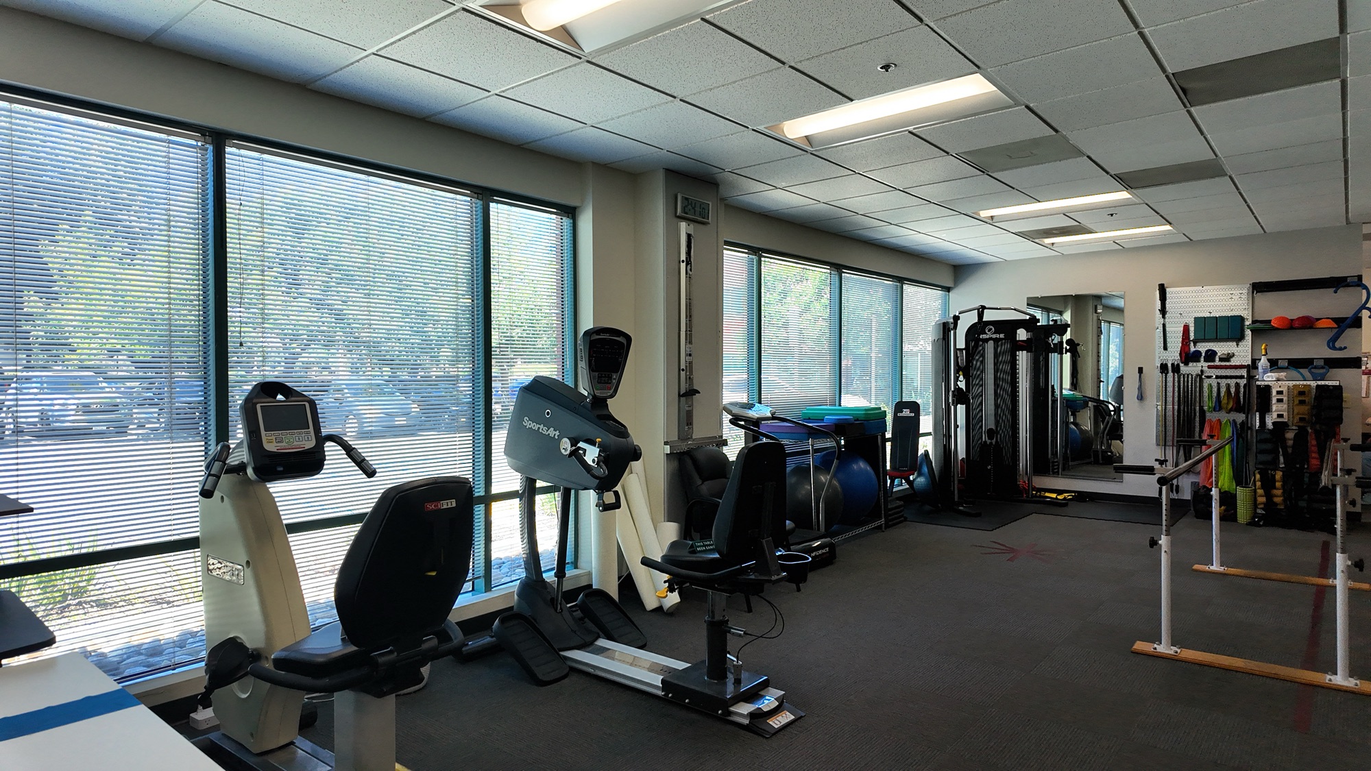 The clinic gym beside a wall of windows