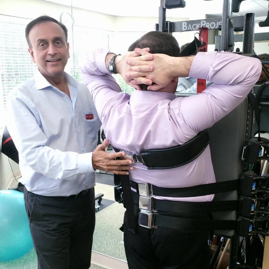 Hiten Davé guiding a patient through a supported back stretch