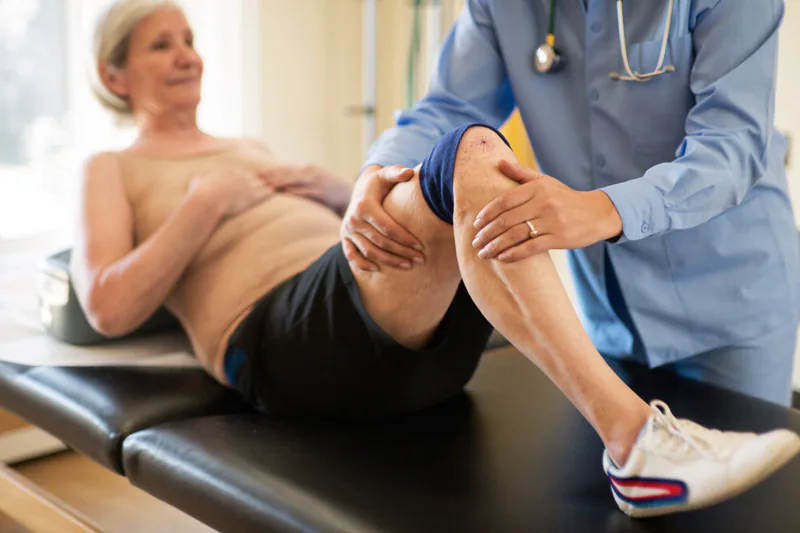 Clinician checking a patient’s bent knee.